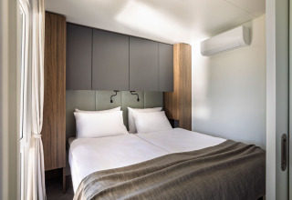 Slaapkamer met twee enkele bedden en een modern interieur in een Premium Holiday Home bij Aminess Planet Camping Sirena, Kroatië.