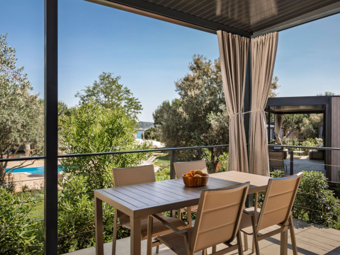 Terras met eettafel en stoelen aan Premium Holiday Home, Aminess Planet Camping Sirena, Kroatië.