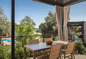 Terraza con mesa y sillas en la Premium Holiday Home, Aminess Planet Camping Sirena, Croacia.