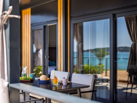Buiteneettafel op het terras van Luxury Holiday Home met uitzicht op zee en een modern design.