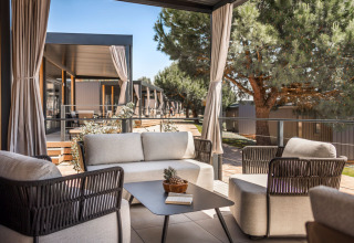 Moderne buitenlounge bij Luxury Holiday Home in Aminess Planet Camping Sirena, Kroatië, met comfortabele stoelen.