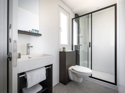 Modern badkamer met inloopdouche, hangtoilet, wastafel en spiegel in Luxury Holiday Home bij Aminess Planet Camping Sirena, Kroatië.