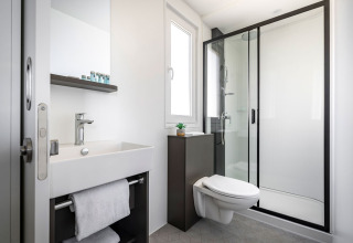 Modern badkamer met inloopdouche, hangtoilet, wastafel en spiegel in Luxury Holiday Home bij Aminess Planet Camping Sirena, Kroatië.