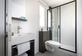Modernes Badezimmer mit Dusche, wandhängender Toilette, Waschbecken und Spiegel im Luxury Holiday Home, Kroatien.