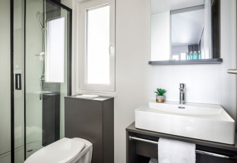 Salle de bain moderne au Luxury Holiday Home d’Aminess Planet Camping Sirena, Croatie, avec douche, lavabo et WC.