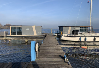 Foto eines Hausboots namens Houseboat «Havenlodge» in der Marina Uitgeest in den Niederlanden mit Bootssteg.