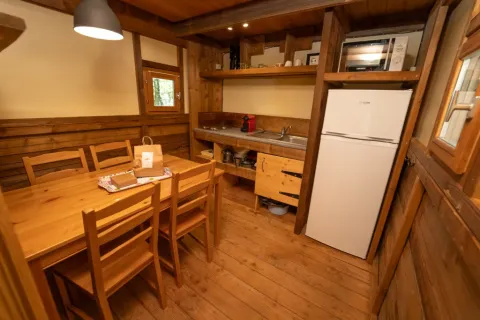 Innenansicht des Safari-Zelts Air Dreamer 2 im Chianti Glamping Resort mit Holzinterieur und Küche.