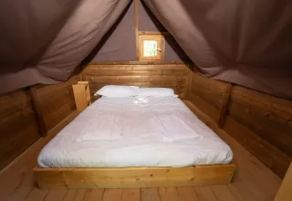 Innenansicht eines Safari-Zeltes mit Doppelbett im 'Air Dreamer 2' im Chianti Glamping Resort, Italien.