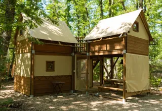 Safari-Zelt Air Dreamer 2 im Chianti Glamping Resort, Italien, umgeben von grünen Bäumen im Wald.