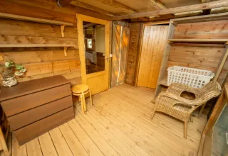 Holzinterieur mit Stuhl, Kommode und Regalen in einem Safari-Zelt im Chianti Glamping Resort, Italien.