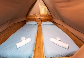 Zwei Einzelbetten mit hellblauer Bettwäsche im Safari-Zelt ‚Air Dreamer‘ 3 im Chianti Glamping Resort, Italien.