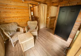 Innenraum des Safari-Zelts „Air Dreamer 3“ im Chianti Glamping Resort, Italien, mit Korbstühlen und Schrank.