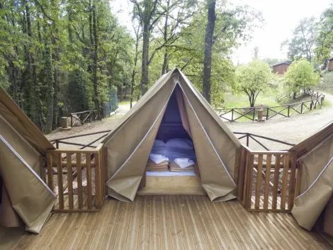 Safari-Zelt Air Dreamer 3 mit Holzterrasse im Chianti Glamping Resort Italien inmitten von grüner Natur.