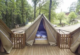 Safari-Zelt Air Dreamer 3 mit Holzterrasse im Chianti Glamping Resort Italien inmitten von grüner Natur.