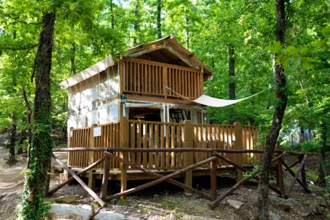 Airlodge 1 at Chianti Glamping Resort in Italy, a cozy wooden lodge surrounded by lush green forest.
