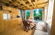 Gemütliches Holzinterieur im Airlodge 2.0 am Chianti Glamping Resort mit Küche, Essbereich und Terrasse.