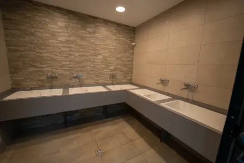 Espace de lavage commun moderne avec plusieurs lavabos et robinets dans une tente safari.