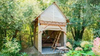 Safari-Zelt „Airstay“ im Chianti Glamping Resort, Italien, umgeben von üppigem grünen Wald.