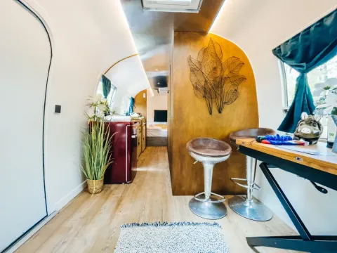 Modern interieur van een Airstream tiny house in Chianti Glamping Resort, Italië, met keuken en eetruimte.