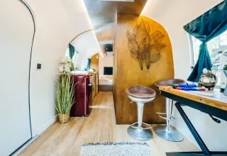 Modern interieur van een Airstream tiny house in Chianti Glamping Resort, Italië, met keuken en eetruimte.
