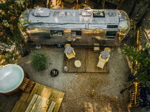 Luchtfoto van het Airstream tiny house met terras en bubbelbad bij Chianti Glamping Resort, Italië.