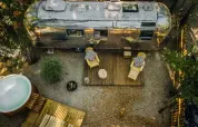 Luftaufnahme des Airstream-Tiny-Houses mit Terrasse und Whirlpool im Chianti Glamping Resort, Italien.