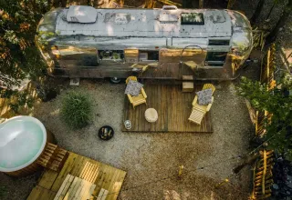 Luchtfoto van het Airstream tiny house met terras en bubbelbad bij Chianti Glamping Resort, Italië.