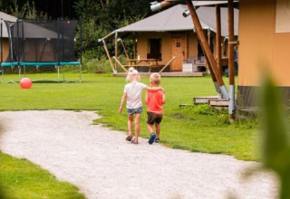 To børn går på en sti ved glamping-telte i ferieparken de Bosweide, Nord-Brabant, Holland.