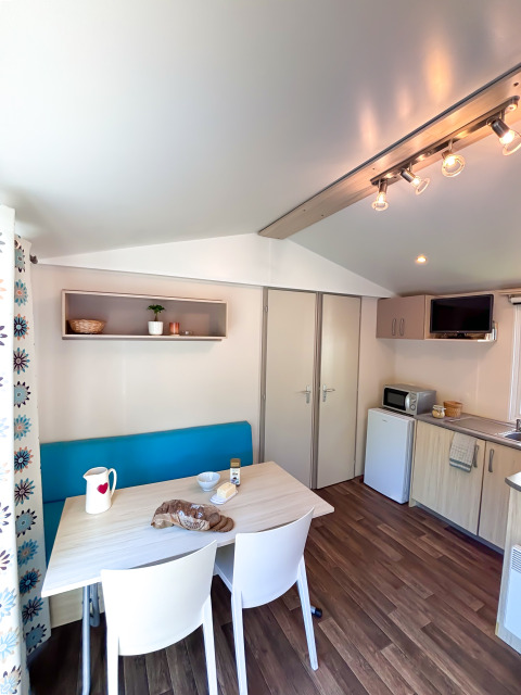 Lyst og moderne køkken og spisestue i Mobile Home Comfort på Campsite Demoiselles Plage i Frankrig.