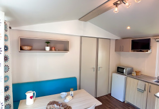 Cucina e zona pranzo luminose e moderne nel Mobile Home Comfort al campeggio Demoiselles Plage in Francia.