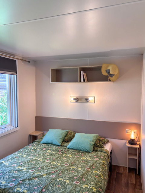 Schlafzimmer im Mobile Home Comfort auf dem Campingplatz Demoiselles Plage, Frankreich; Doppelbett und einfache Einrichtung.