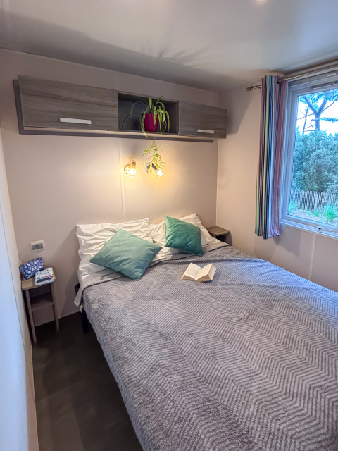Camera da letto nel Mobile Home Comfort al Campeggio Demoiselles Plage, Francia, con letto matrimoniale.