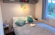 Bedroom at Mobile Home Comfort in Campsite Demoiselles Plage, France, featuring a double bed and window.