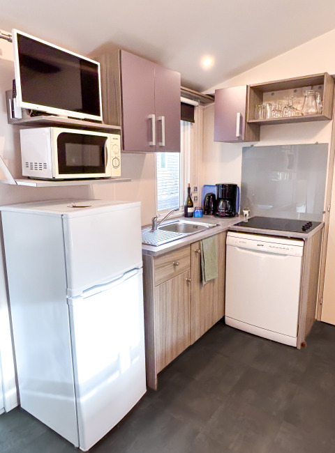 Kompakt køkken i Mobile Home Comfort, Campsite Demoiselles Plage, med ovn, køleskab og opvaskemaskine.