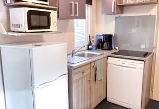 Cucina compatta al Mobile Home Comfort, Campsite Demoiselles Plage, con frigo, microonde e lavastoviglie.