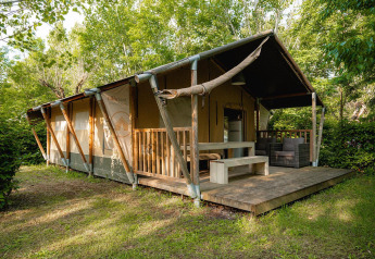 Tenda safari Villatent Nomad con veranda in legno al Camping La Chiocciola, Italia, immersa nel verde.