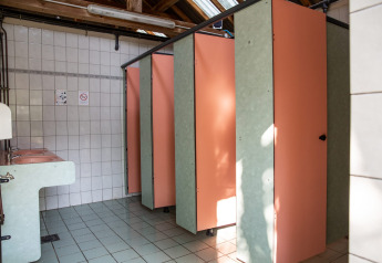 Bathroom with pink stalls and sinks at the Safari tent at Campsite Les Bouleaux in France.