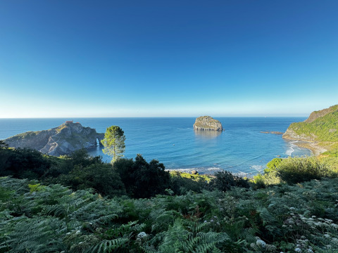 Küstenblick mit Insel und Klippe im Wecamp Cudillero Ferienpark in Asturien, Spanien, an einem klaren Tag.