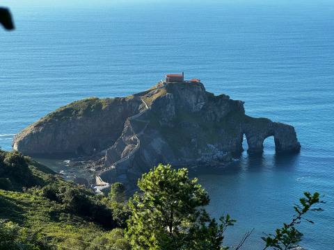 Blick auf eine berühmte Felseninsel mit Stufenweg und Haus auf der Spitze bei Wecamp Cudillero, Asturien, Spanien.