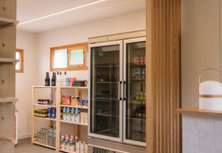 Moderner Laden im Wecamp Cudillero, Asturien, Spanien mit Holzregalen und einem großen Kühlschrank.