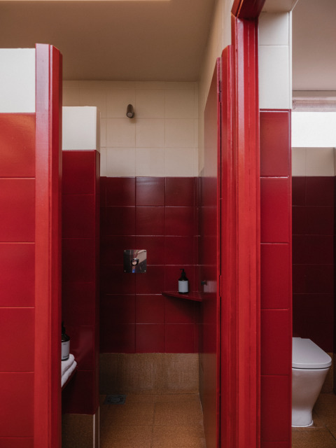 Modernes Gemeinschaftsbad mit roten Fliesen, Dusche und WC im Wecamp Cudillero, Asturias, Spanien.