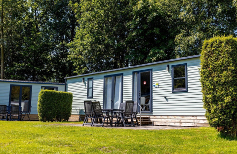 Outdoor view of Lodge XL - comfort at Holiday Park Bergumermeer in the Netherlands, with patio seating.