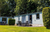 Outdoor view of Lodge XL - comfort at Holiday Park Bergumermeer in the Netherlands, with patio seating.