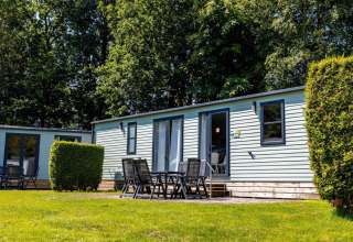 Outdoor view of Lodge XL - comfort at Holiday Park Bergumermeer in the Netherlands, with patio seating.