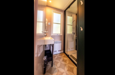 Modern bathroom with glass shower, sink, and windows at Lodge «XL - comfort» in Holiday Park Bergumermeer.