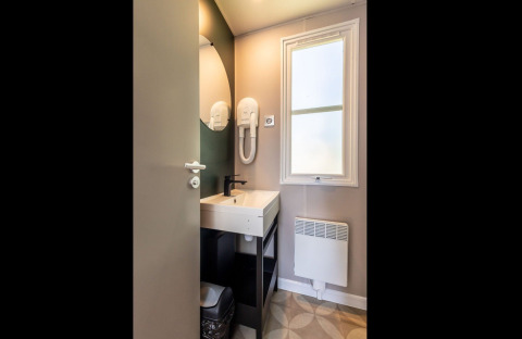 Modern bathroom with sink, mirror, hairdryer and window in Lodge «XL - comfort» at Bergumermeer, Netherlands.