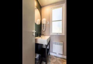 Modern bathroom with sink, mirror, hairdryer and window in Lodge «XL - comfort» at Bergumermeer, Netherlands.