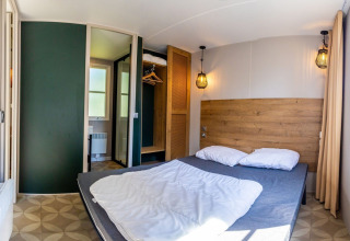 Comfortable bedroom in Lodge XL - comfort at Holiday Park Bergumermeer with double bed and modern décor.