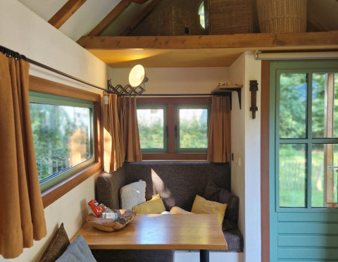 Coin salon douillet dans la tiny house «Hans en Grietje» à Buytenplaets Suydersee, Pays-Bas, avec table.
