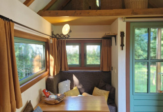 Coin salon douillet dans la tiny house «Hans en Grietje» à Buytenplaets Suydersee, Pays-Bas, avec table.